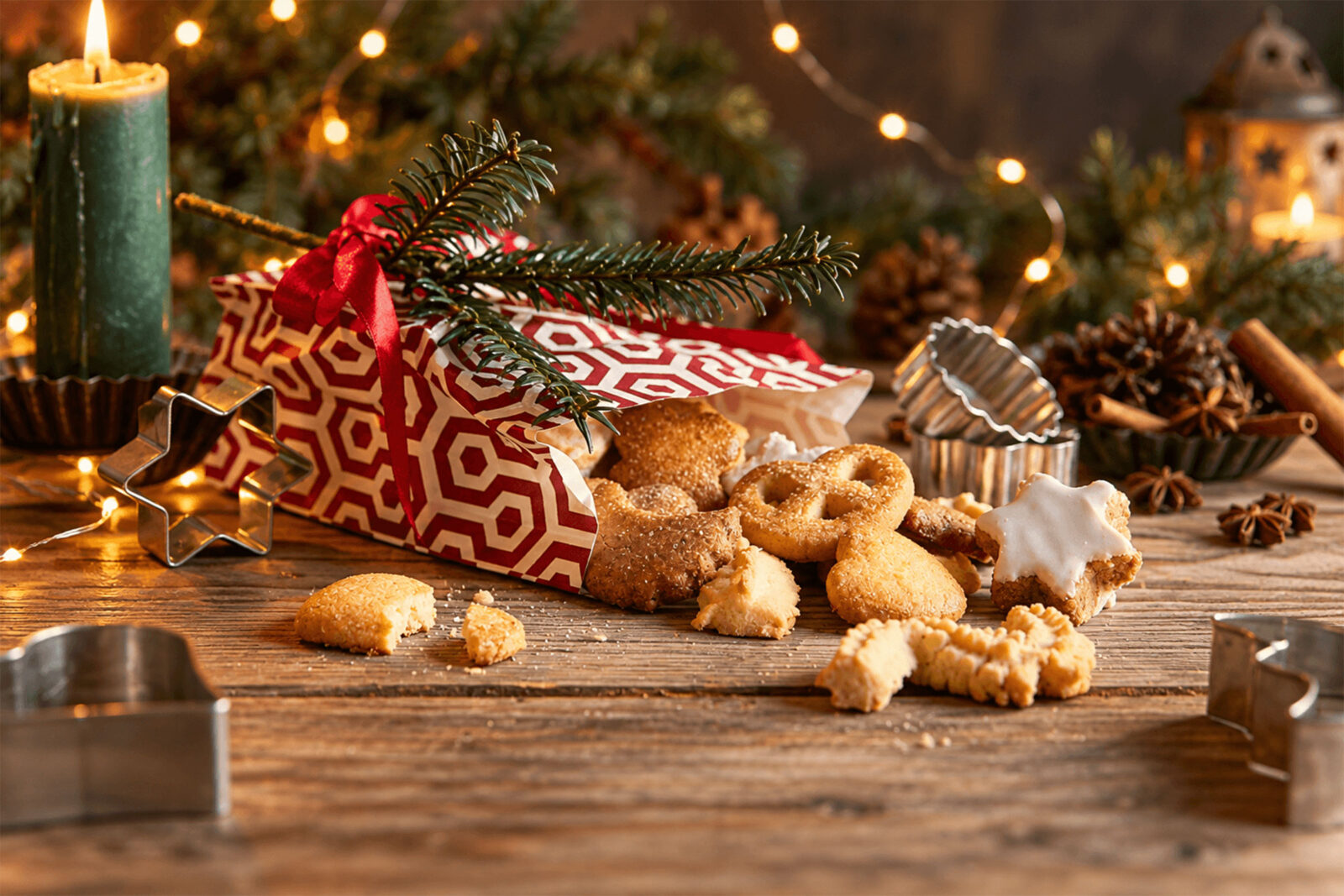 Bredele, petits gâteaux de Noël alsaciens, posés sur une table en bois avec emporte-pièces et branches de sapin